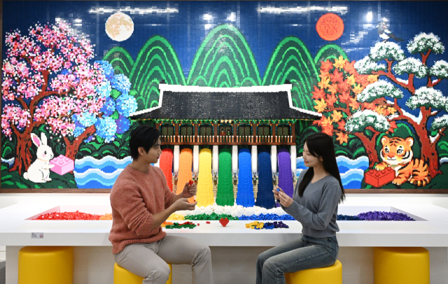 4일 서울 용산구 아이파크몰 용산점 리빙파크 6층에서 열린 공식 레고스토어 용산점 프리 오픈 행사에서 모델들이 광화문과 근정전을 구현한 레고 작품을 관람하고 있다. 권욱 기자 2025.12.4