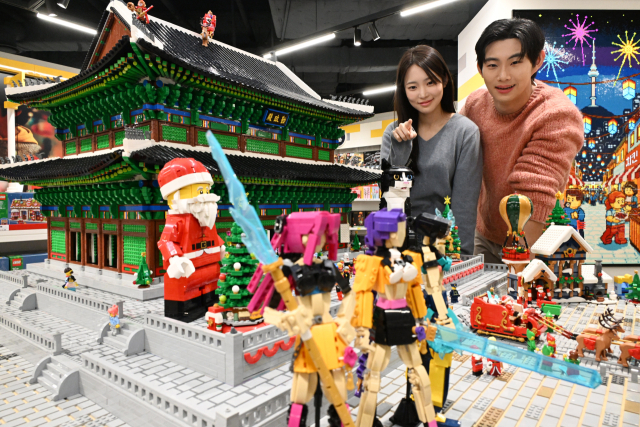 4일 서울 용산구 아이파크몰에 사전 오픈한 레고스토어 용산점 프리 오픈 행사에서 모델들이 광화문과 근정전을 구현한 레고 작품을 관람하고 있다. 국내 최대 규모로 5일 정식 오픈하는 레고스토어 용산점은 ‘K컬처’를 테마로 한국 문화를 재해석한 레고 작품과 체험 공간을 선보인다. 권욱 기자