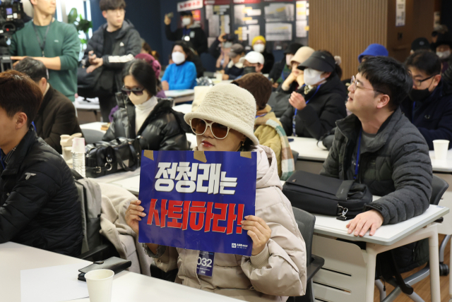 1일 서울 여의도 더불어민주당 중앙당사 당원존에서 열린 '당원 주권 정당 실현을 위한 제도개선 토론회'에 참석한 민주당원이 정청래 대표를 규탄하는 손팻말을 들고 있다. 연합뉴스