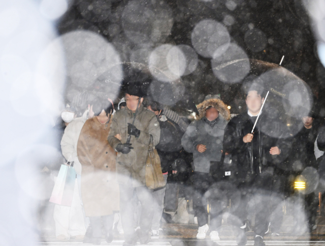 서울에 첫눈이 내린 4일 서울 종로구 거리에서 시민들이 퇴근길 발걸음을 재촉하고 있다. 5일 전국의 아침 최저기온이 -11∼2도, 낮 최고기온은 1∼9도로 추운 날씨가 이어지면서 전날 내린 눈으로 인해 아침부터 빙판길이 예상된다. 오승현 기자 2025.12.04