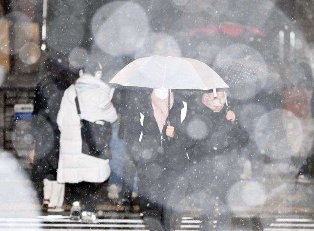 서울에 첫눈이 내린 4일 서울 종로구 거리에서 시민들이 퇴근길 발걸음을 재촉하고 있다. 5일 전국의 아침 최저기온이 -11∼2도, 낮 최고기온은 1∼9도로 추운 날씨가 이어지면서 전날 내린 눈으로 인해 아침부터 빙판길이 예상된다. 오승현 기자 2025.12.04