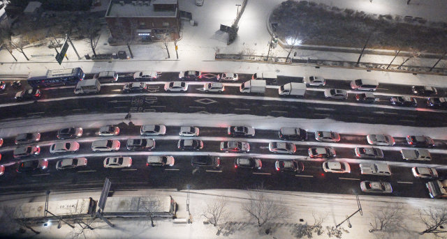 서울에 첫눈이 내린 4일 서울 종로구 율곡로가 퇴근길 차량으로 정체를 빚고 있다. 5일 전국의 아침 최저기온이 -11∼2도, 낮 최고기온은 1∼9도로 추운 날씨가 이어지면서 전날 내린 눈으로 인해 아침부터 빙판길이 예상된다. 오승현 기자 2025.12.04