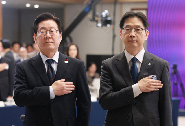 이재명 대통령이 8일 용산 대통령실 청사에서 열린 지방시대위원회 보고회에서 국기에 경례하고 있다. 오른쪽은 김경수 지방시대위원장. 연합뉴스