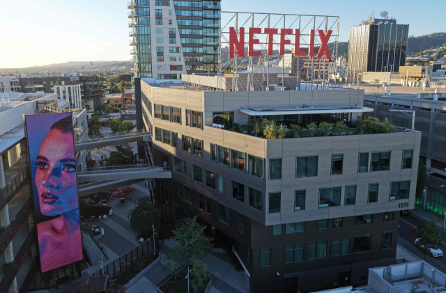 5일(현지시간) 미국 캘리포니아 로스엔젤레스의 넷플릭스 사옥 위로 회사 로고가 걸려있다. 넷플릭스는 최근 미국의 전통 콘텐츠·방송 업체인 워너브러더스디스커버리를 인수하는 계약을 체결하면서 글로벌 콘텐츠 시장의 격변을 예고했다.AFP연합뉴스