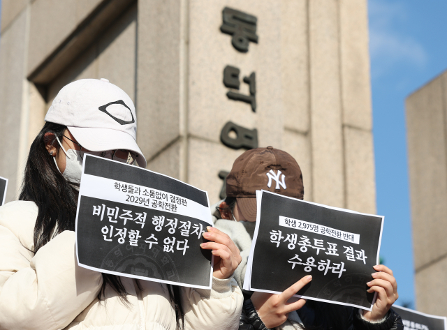 9일 서울 성북구 동덕여자대학교 정문에서 열린 '2025 학생총투표 결과 전달 기자회견'에서 학생들이 공학 전환에 반대하는 내용의 손팻말을 들고 있다. 연합뉴스