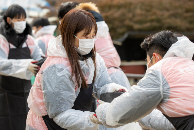 호반그룹 임직원들이 지난 9일 서울 서초구 방배동 전원마을에서 ‘사랑의 연탄 나눔’ 봉사활동을 진행하며 지역 이웃들에게 연탄을 전달하고 있다. 사진 제공=호반그룹